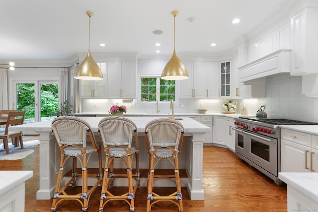 13 Witch Ln, Norwalk, CT 06853 - kitchen featuring range with two ovens, plenty of natural light, white cabinets, crown molding, and recessed lighting