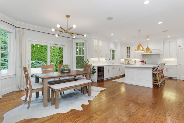 13 Witch Ln, Norwalk, CT 06853 - dining area featuring wine cooler, a chandelier, plenty of natural light, dark wood-style floors, and ornamental molding