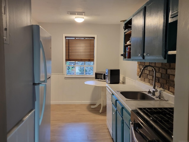 50 Greenhouse Rd Unit 41C, Bridgeport, CT 06606 - kitchen featuring a sink, freestanding refrigerator, light wood-style flooring, range, and a wainscoted wall