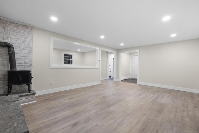 23 Aunt Pattys Ln W, Bethel, CT 06801 - unfurnished living room featuring a wood stove, light wood-style flooring, recessed lighting, and baseboards