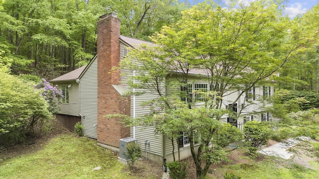 23 Aunt Pattys Ln W, Bethel, CT 06801 - view of side of home featuring a chimney, cooling unit, and a shingled roof