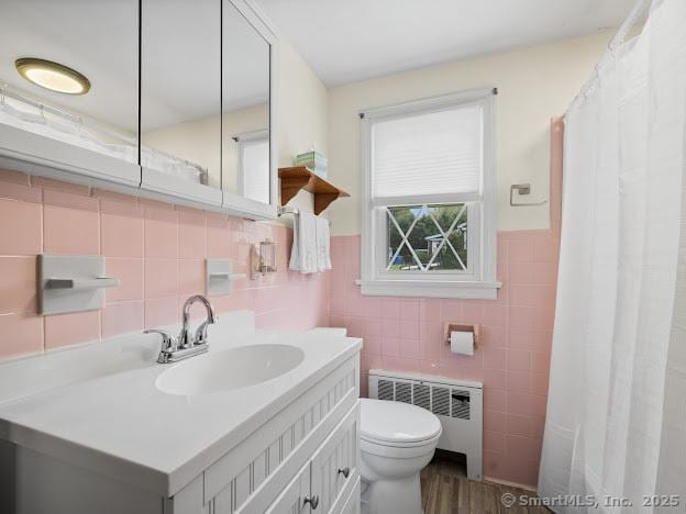 21 Poplar St, Enfield, CT 06082 - full bath featuring radiator, tile walls, toilet, vanity, and wood finished floors