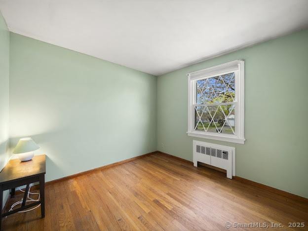 21 Poplar St, Enfield, CT 06082 - empty room with radiator and wood finished floors