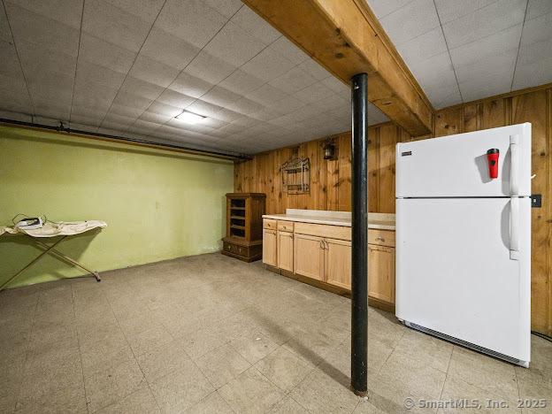 21 Poplar St, Enfield, CT 06082 - finished basement featuring freestanding refrigerator, wood walls, and light flooring