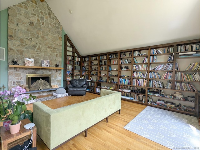 21 Holiday Point Rd, Sherman, CT 06784 - living area featuring wood finished floors, bookshelves, high vaulted ceiling, a fireplace, and beam ceiling