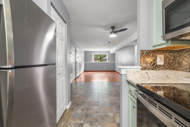 500 Darling St Unit 12M, Southington, CT 06489 - kitchen featuring stainless steel appliances, ceiling fan, baseboards, tasteful backsplash, and stone finish flooring