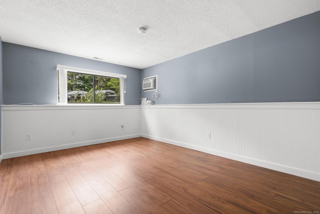 500 Darling St Unit 12M, Southington, CT 06489 - spare room featuring a wainscoted wall, wood finished floors, a textured ceiling, a wall mounted air conditioner, and a smoke detector
