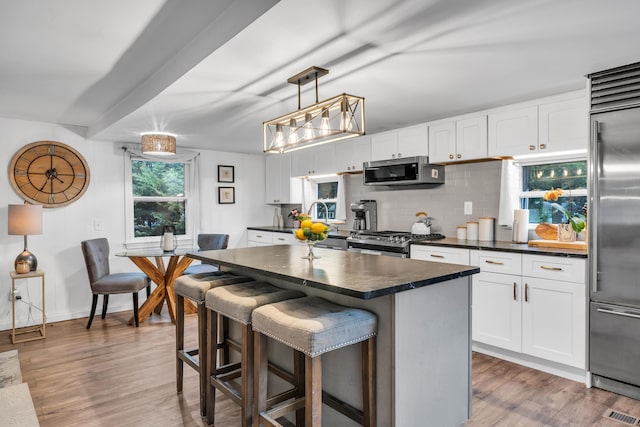 13 Green Acres Park Dr, Westbrook, CT 06498 - kitchen featuring stainless steel appliances, dark countertops, decorative backsplash, and wood finished floors