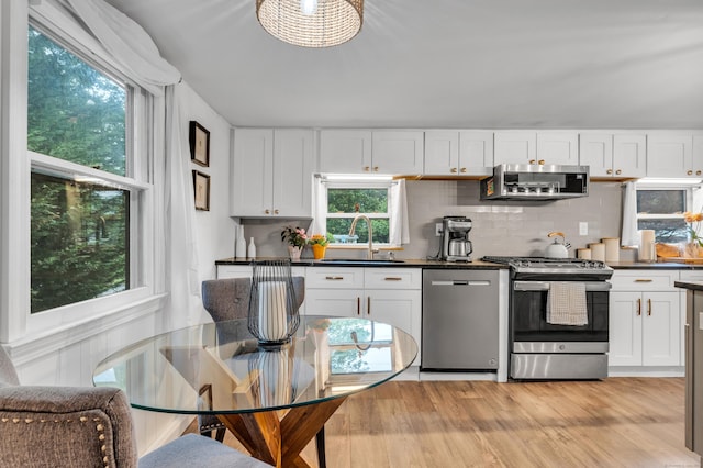 13 Green Acres Park Dr, Westbrook, CT 06498 - kitchen featuring stainless steel appliances, dark countertops, white cabinetry, and plenty of natural light