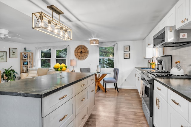 13 Green Acres Park Dr, Westbrook, CT 06498 - kitchen with stainless steel appliances, dark countertops, wood finished floors, decorative backsplash, and white cabinets
