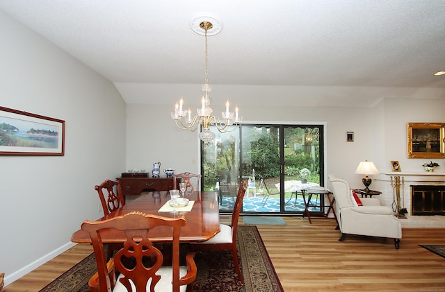 278 Heritage Vlg Unit B, Southbury, CT 06488 - dining space with a chandelier, light wood-style floors, a fireplace, and baseboards