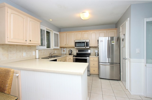 278 Heritage Vlg Unit B, Southbury, CT 06488 - kitchen featuring appliances with stainless steel finishes, a peninsula, light countertops, decorative backsplash, and light tile patterned floors