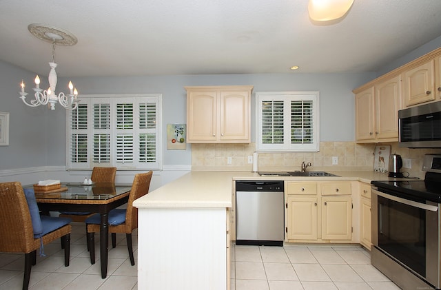 278 Heritage Vlg Unit B, Southbury, CT 06488 - kitchen featuring stainless steel appliances, a chandelier, a peninsula, light tile patterned flooring, and light countertops