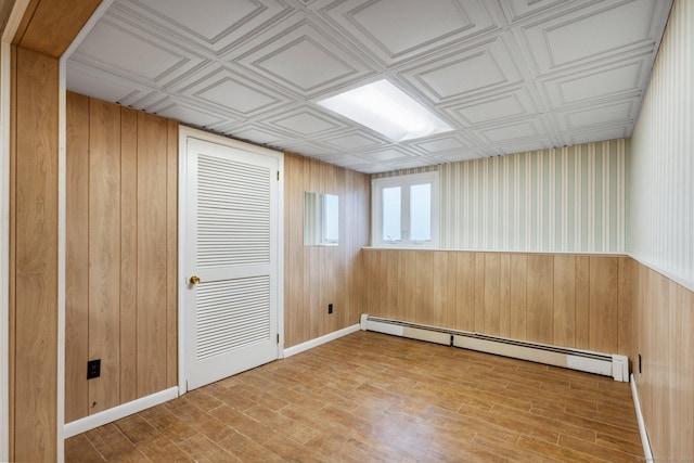43 Worthington Rd, Glastonbury, CT 06033 - empty room with a baseboard radiator, wood walls, wood finished floors, an ornate ceiling, and baseboards