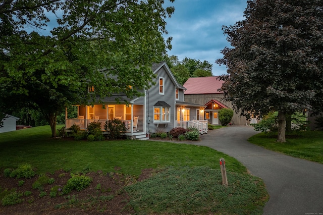 113 E Rd, East Windsor, CT 06016 - view of front facade featuring driveway, covered porch, a front lawn, and metal roof