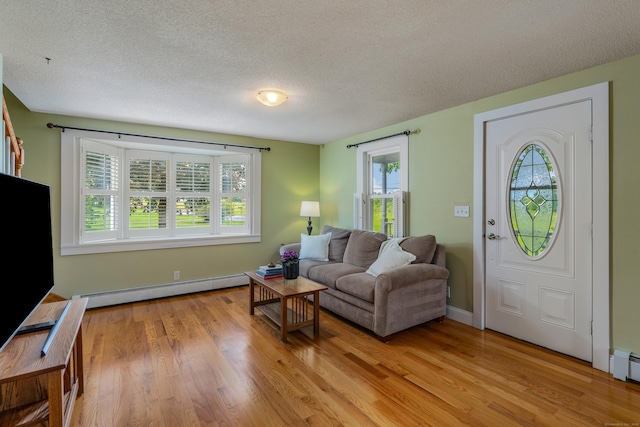 113 E Rd, East Windsor, CT 06016 - living area with baseboard heating, plenty of natural light, light wood-style floors, and a textured ceiling