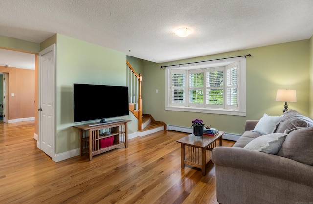 113 E Rd, East Windsor, CT 06016 - living room featuring wood finished floors, stairs, a baseboard radiator, a textured ceiling, and baseboards