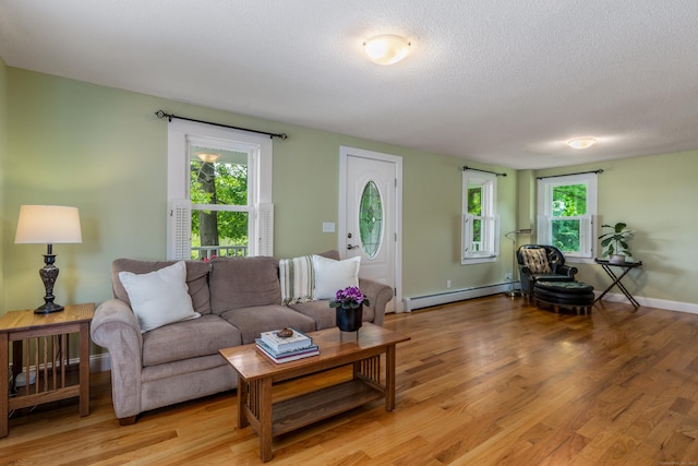 113 E Rd, East Windsor, CT 06016 - living area with a baseboard heating unit, light wood-type flooring, a textured ceiling, and baseboards