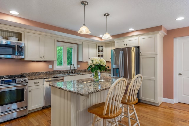 113 E Rd, East Windsor, CT 06016 - kitchen with appliances with stainless steel finishes, a sink, light wood-style flooring, a breakfast bar, and recessed lighting