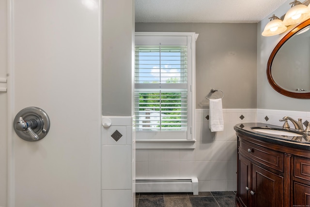 113 E Rd, East Windsor, CT 06016 - bathroom featuring baseboard heating, tile walls, vanity, a wainscoted wall, and a textured ceiling