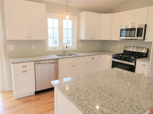148 Gallup Hill Rd, Ledyard, CT 06339 - kitchen featuring stainless steel appliances, a sink, light wood-type flooring, white cabinets, and vaulted ceiling