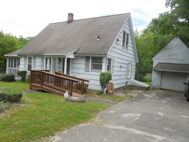 85 Blackberry Hill Rd, Beacon Falls, CT 06403 - view of front facade featuring a chimney, a detached garage, roof with shingles, and a front yard