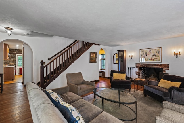 128 Blake Rd, Hamden, CT 06517 - living room with arched walkways, dark wood-style floors, plenty of natural light, stairway, and a textured ceiling