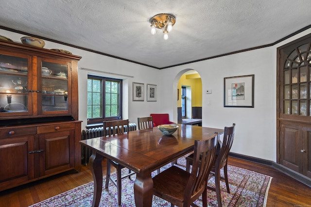 128 Blake Rd, Hamden, CT 06517 - dining space with arched walkways, a textured ceiling, dark wood finished floors, and crown molding