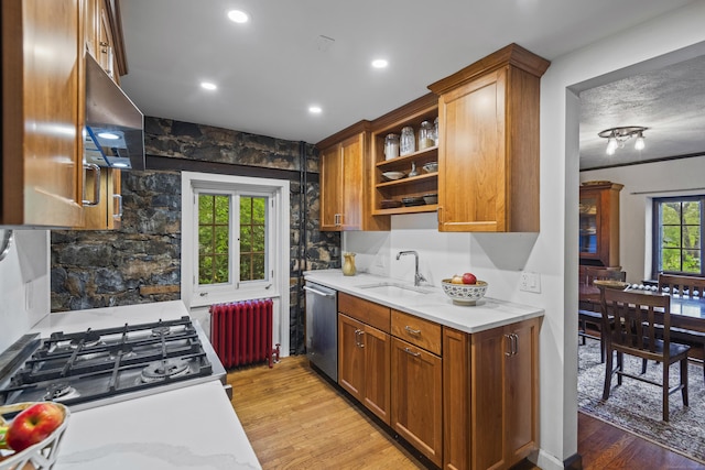 128 Blake Rd, Hamden, CT 06517 - kitchen featuring radiator heating unit, stainless steel dishwasher, a sink, light wood-style flooring, and stove