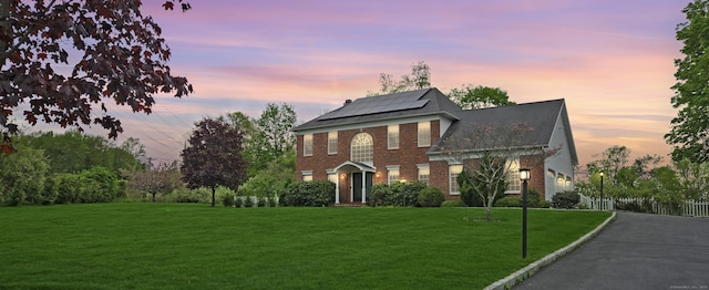 15 Wellington Ct, Shelton, CT 06484 - view of front facade with roof mounted solar panels, brick siding, and asphalt driveway