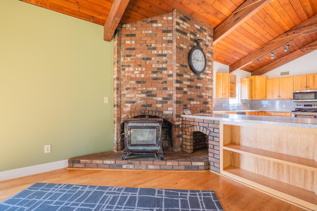 125 Woodchuck Ln, Harwinton, CT 06791 - kitchen with appliances with stainless steel finishes, a wood stove, wood ceiling, light brown cabinets, and baseboards