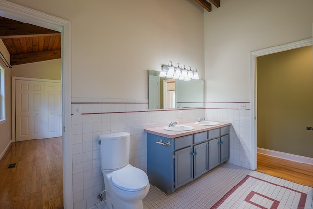 125 Woodchuck Ln, Harwinton, CT 06791 - full bathroom featuring tile walls, toilet, double vanity, wood finished floors, and wood ceiling