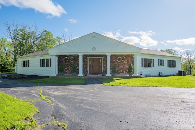 125 Woodchuck Ln, Harwinton, CT 06791 - neoclassical / greek revival house with central AC unit, a porch, a front yard, and brick siding