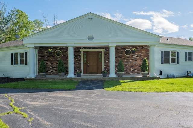 125 Woodchuck Ln, Harwinton, CT 06791 - greek revival house featuring covered porch, brick siding, and a front lawn