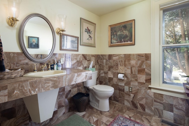 308 Main St, Salisbury, CT 06039 - half bathroom featuring a sink, toilet, tile walls, and wainscoting