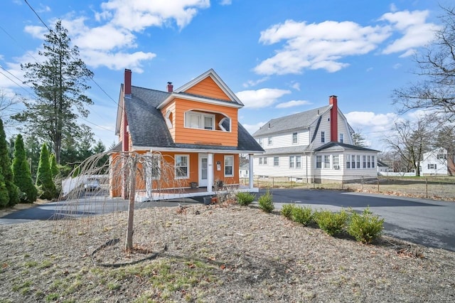 809 Burnside Ave, East Hartford, CT 06108 - view of front facade featuring a porch, a chimney, asphalt driveway, and roof with shingles