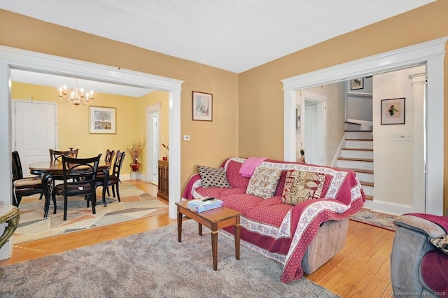 809 Burnside Ave, East Hartford, CT 06108 - living area with a chandelier, light wood-type flooring, stairs, and baseboards