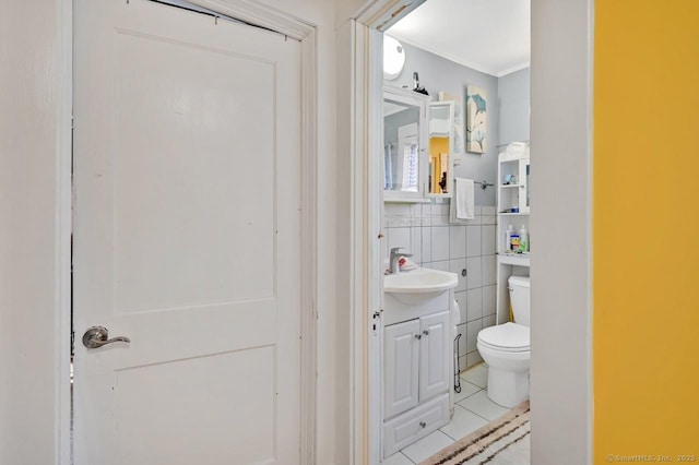 809 Burnside Ave, East Hartford, CT 06108 - bathroom with toilet, vanity, ornamental molding, tile patterned floors, and tile walls