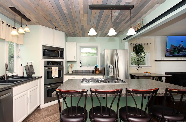 156 Clinton Hill Rd, Wolcott, CT 06716 - kitchen featuring appliances with stainless steel finishes, a sink, dark countertops, a kitchen bar, and wooden ceiling