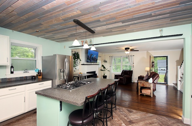 156 Clinton Hill Rd, Wolcott, CT 06716 - kitchen featuring appliances with stainless steel finishes, dark countertops, a kitchen breakfast bar, open floor plan, and white cabinets