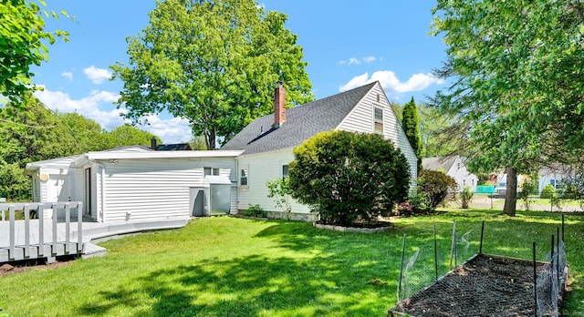 43 Ronald Rd, New Britain, CT 06053 - back of property with a lawn, a wooden deck, a chimney, and a vegetable garden