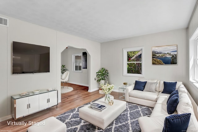 43 Ronald Rd, New Britain, CT 06053 - living room featuring wood finished floors, arched walkways, and baseboards