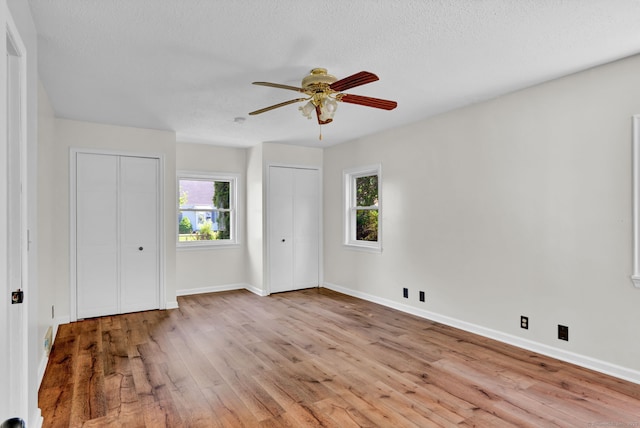 43 Ronald Rd, New Britain, CT 06053 - unfurnished bedroom featuring multiple closets, wood finished floors, multiple windows, and a textured ceiling