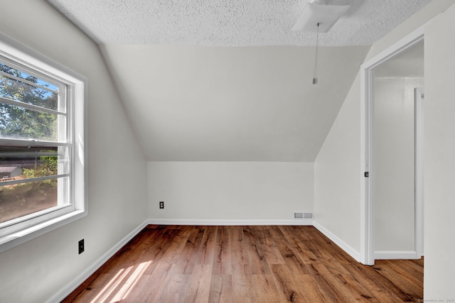 43 Ronald Rd, New Britain, CT 06053 - additional living space featuring healthy amount of natural light, hardwood / wood-style flooring, lofted ceiling, a textured ceiling, and baseboards