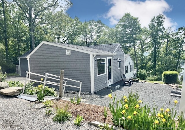 25 Mohawk Trl, East Hampton, CT 06424 - view of property exterior with a shingled roof and view of wooded area