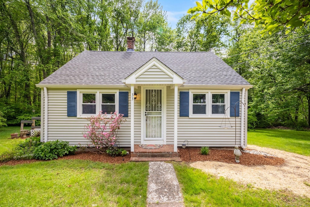 33 Hurlbut Rd, Tolland, CT 06084 - bungalow-style house featuring roof with shingles, a front lawn, and a chimney