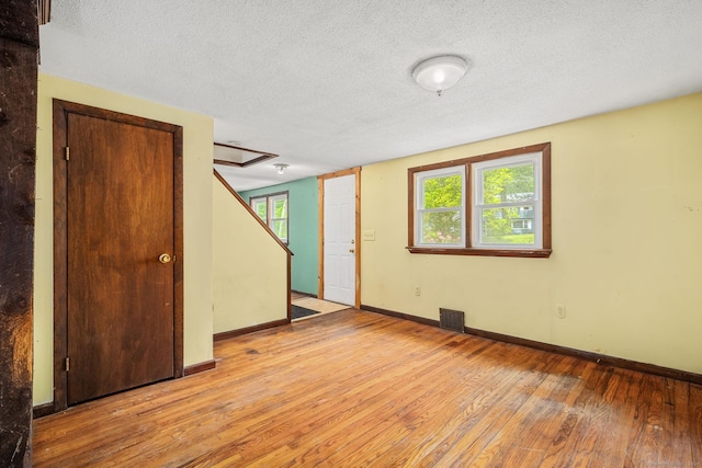 33 Hurlbut Rd, Tolland, CT 06084 - unfurnished room featuring light wood-style flooring, baseboards, a textured ceiling, and stairs
