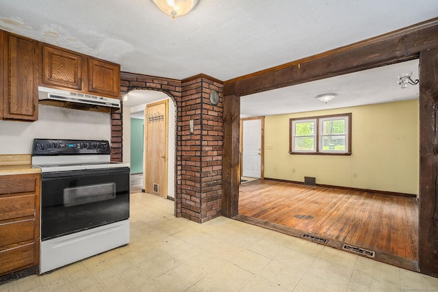 33 Hurlbut Rd, Tolland, CT 06084 - kitchen with white electric range oven, under cabinet range hood, arched walkways, a textured ceiling, and light countertops