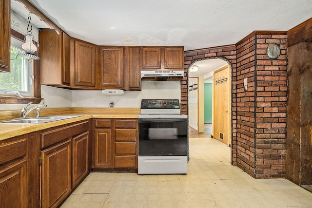 33 Hurlbut Rd, Tolland, CT 06084 - kitchen with electric range oven, a sink, under cabinet range hood, brick wall, and light floors