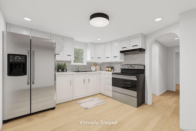33 Hurlbut Rd, Tolland, CT 06084 - kitchen with stainless steel appliances, arched walkways, under cabinet range hood, backsplash, and light countertops